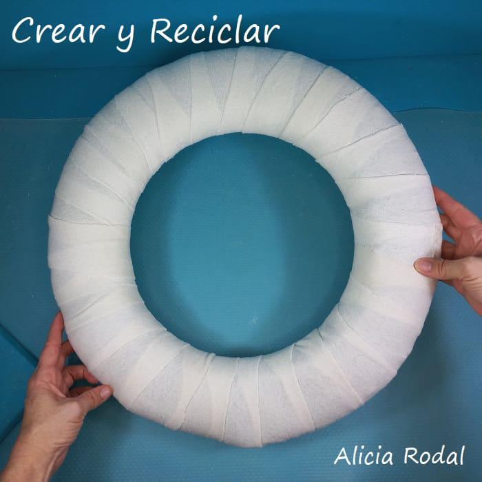 Mira qué fácil es hacer una preciosa corona navideña para decorar la puerta de entrada de tu casa estas Navidades, y lo mejor de todo es que es muy económica, ya que no tendrás que gastar mucho dinero, porque está hecha en su mayoría por materiales reciclados. DIY