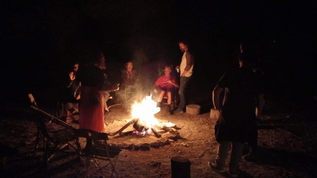 Gente alrededor de una fogata en la noche de Samhain