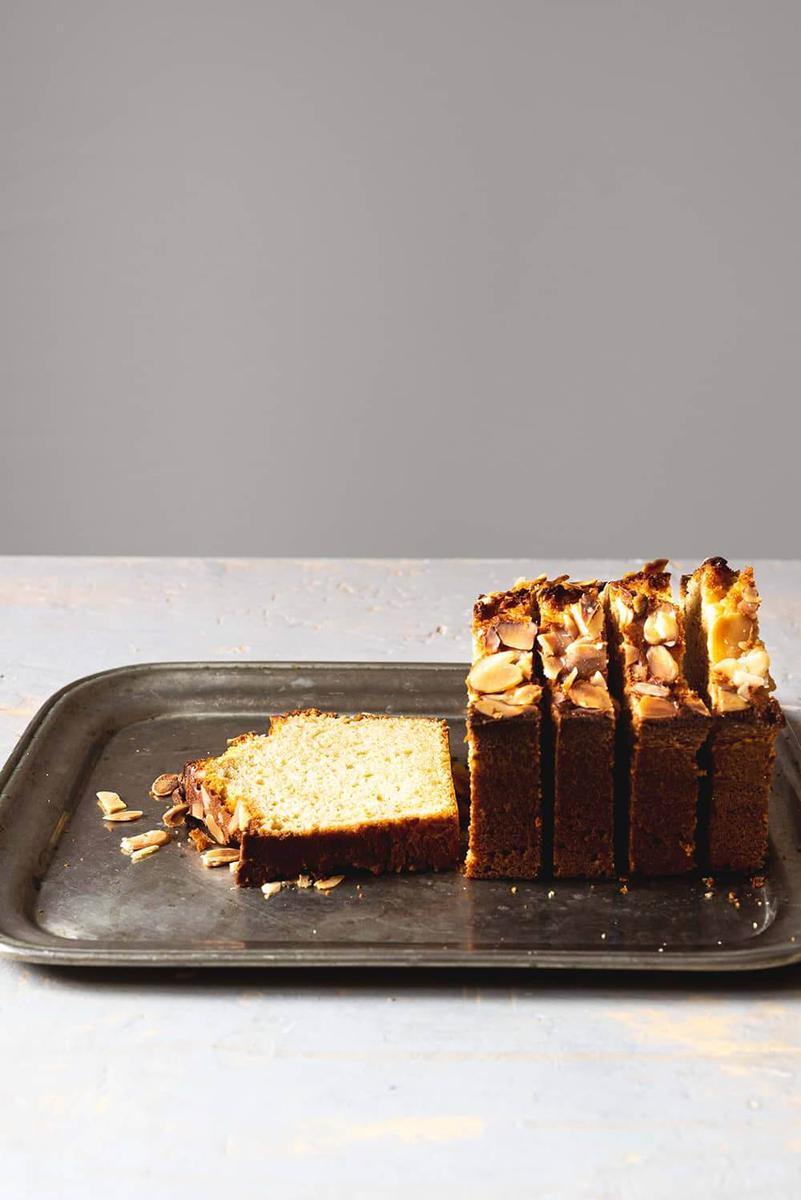 En una mesa blanca hay una bandeja de metal. Encima de la bandeja está el bizcocho de turrón de Jijona ya totalmente cortado.