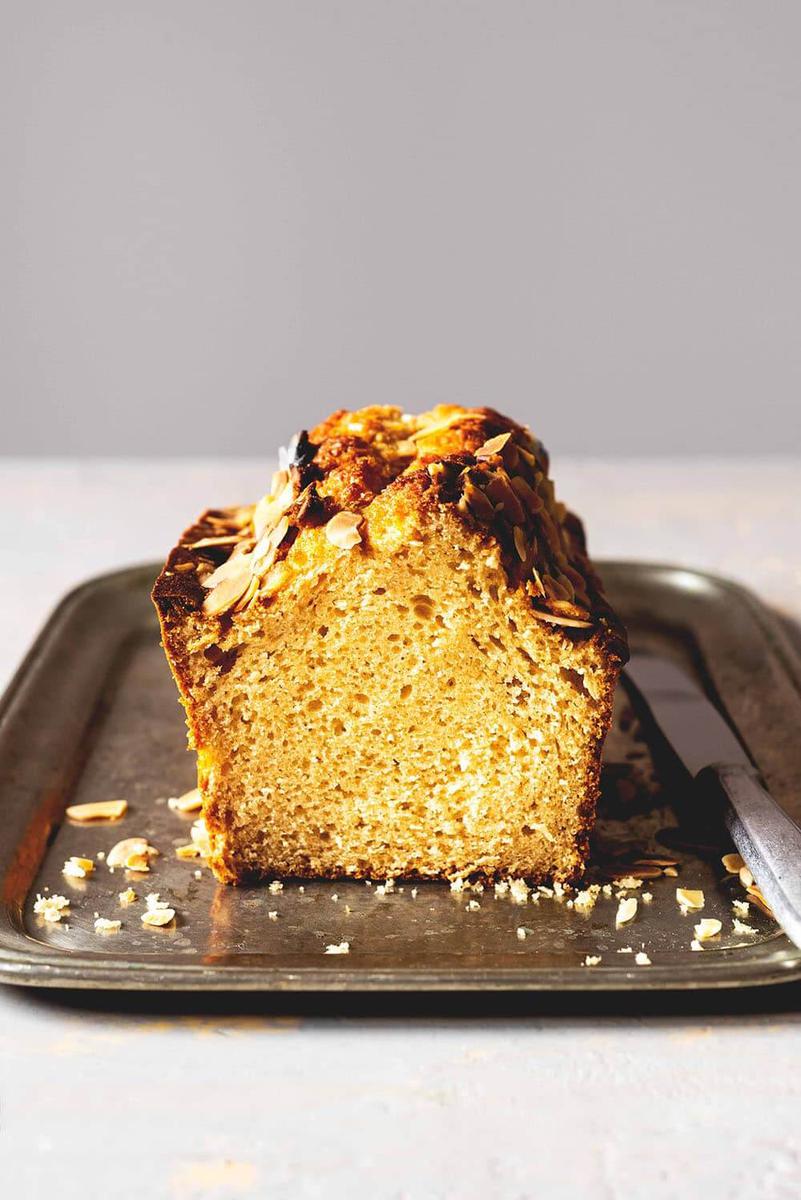 En una mesa blanca hay una bandeja de metal. Encima de la bandeja está el bizcocho de turrón de Jijona esponjoso.