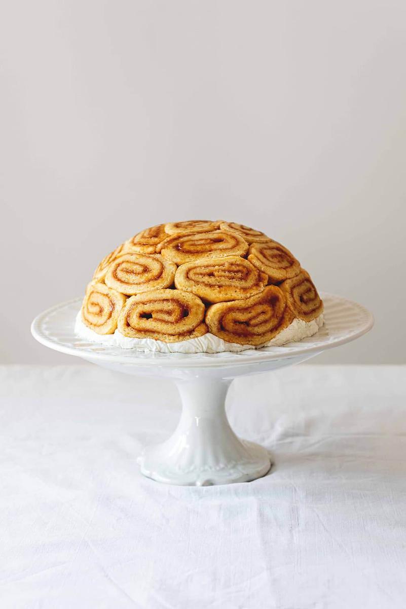 En una superficie blanca está una porta tarta. En ella está Charlotte royale de melocotón. 