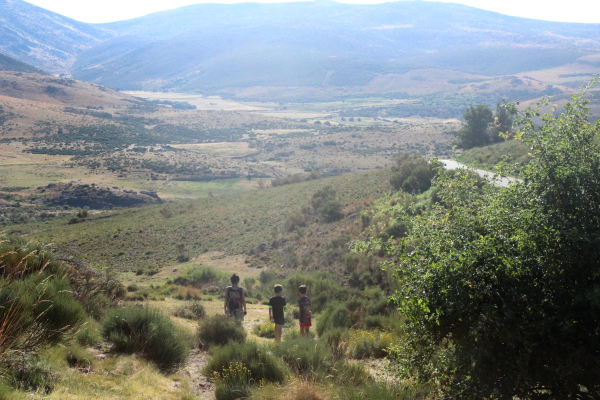 Vista de niños y mujer en un paisaje de valle