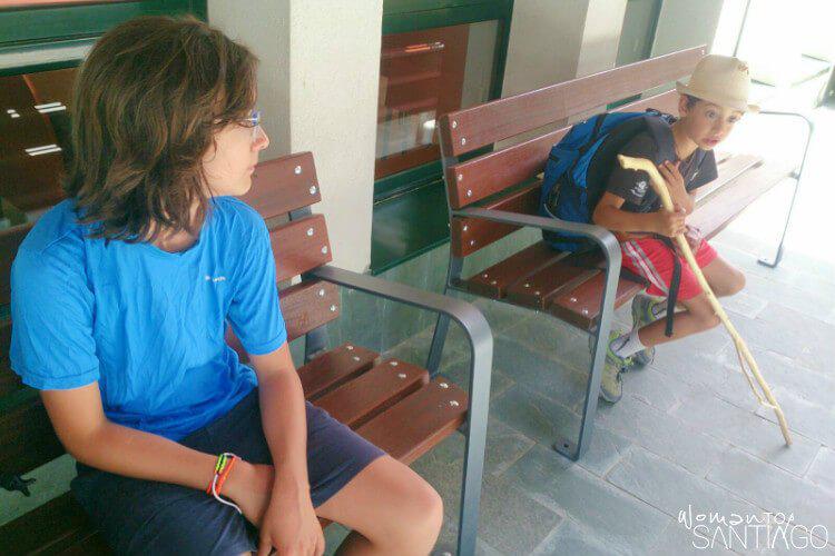 niños en el camino sentados en dos bancos