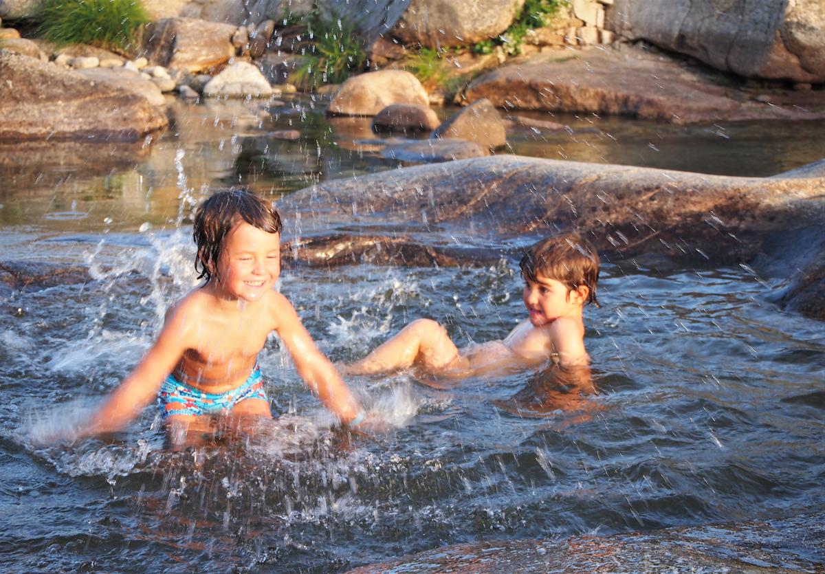 Niños en un rio salpicando agua