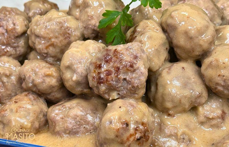 Plato de albóndigas suecas con salsa cremosa servido con puré de patatas 