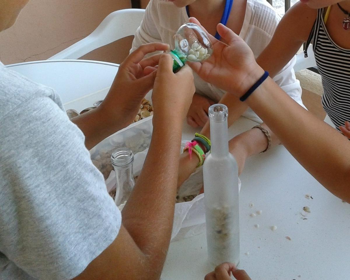 reciclando botellas de cristal con niños. conchas de playa embotelladas