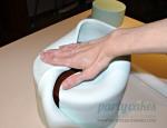Fold top of the fondant down onto the top of your cake, taking care to press out any air so you don