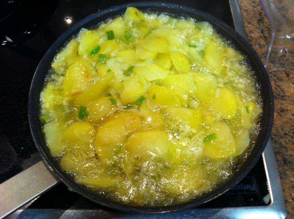 Friendo la patata con la cebolla y el pimiento verde