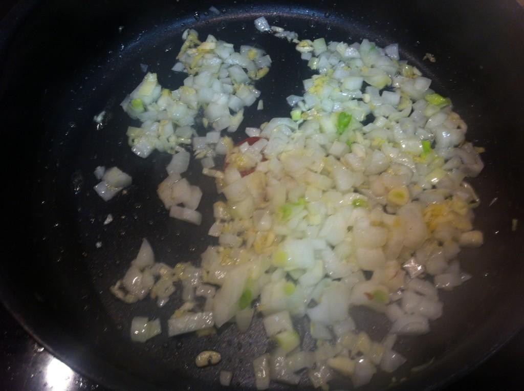 Salteando la cebolla con el ajo y el gengibre.