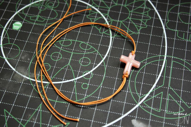 Hacer nudo con el cordon de cuero alrededor de la cruz