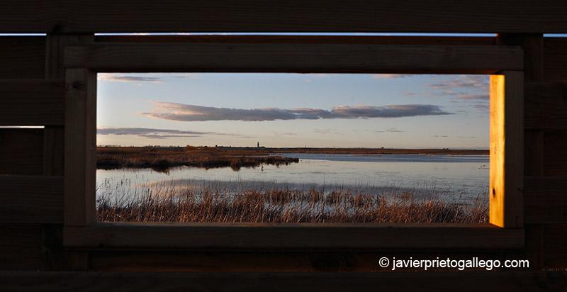 Ventana de uno de los observatorios de la laguan de La Nava desde la que se ve la laguna con la población de Fuentes de Nava al fondo. Al atardecer. Tierra de Campos. Palencia. Castilla y León. España.© Javier Prieto Gallego