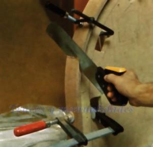 El arco está constituido por tres tiras de tablero de fibras encoladas entre si mediante una plantilla de tablero aglomerado. Con el serrucho de costilla se aguzan los extremos del arco para que encajen con los laterales del marco.