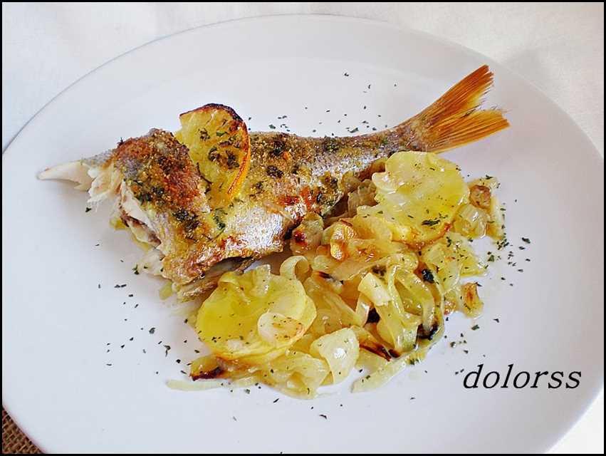 Besugo al horno sobre lecho de patat y cebolla Pescado al horno típico de navidad