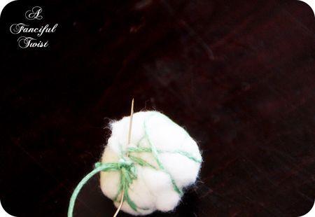 bola de algodon atada para hacer guirnalda de navidad
