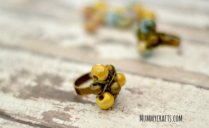 Anillo con hilo metálico y bola de ceramica mostaza