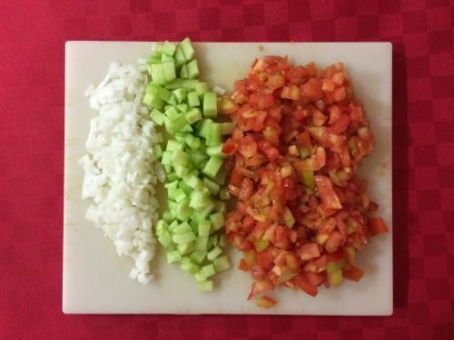 Cortando el tomate, pepino y cebolla fresca en dados