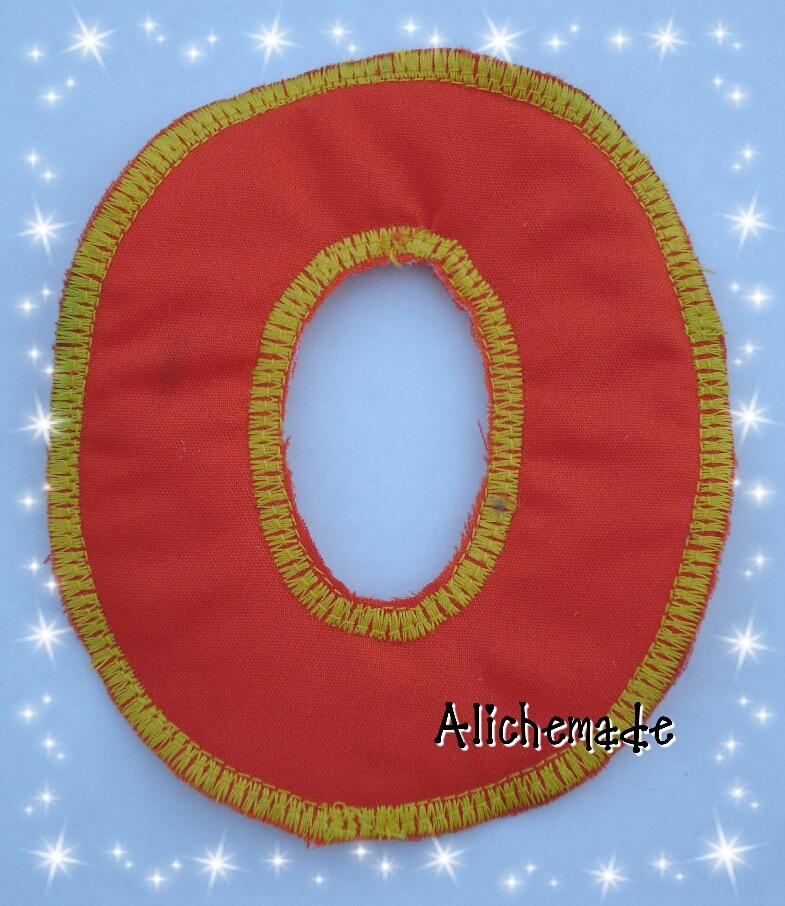 Letra de tela reversible, O. Aunque en la fotografía no se aprecia, la O es roja, no sabemos porque parece naranja como la H?.