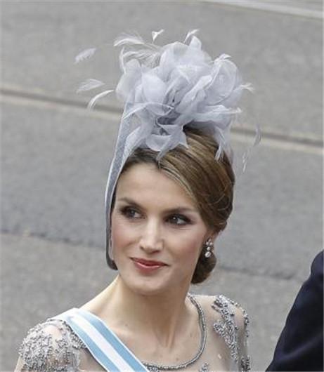 Reina Letizia Ortiz con tocado de plumas y recogido bajo