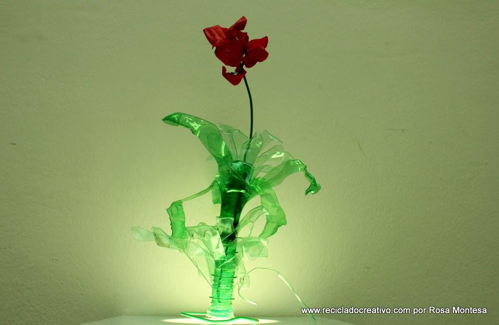 Flor de color rojo pasión con botellas de plástico